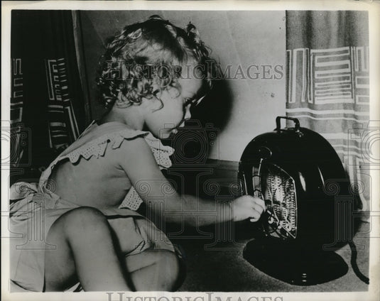 1954 Press Photo child with new safer electic heater, 3300 children die each yr - Historic Images