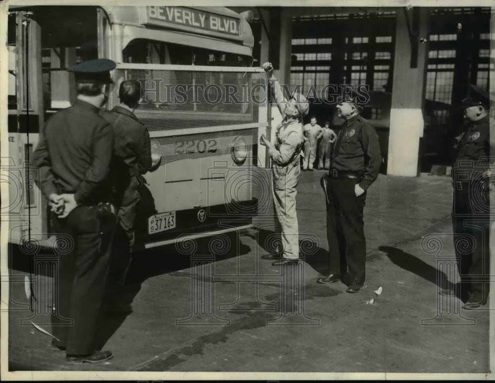 1934 Press Photo Heavy wire netting being installed on bus as safety device in - Historic Images