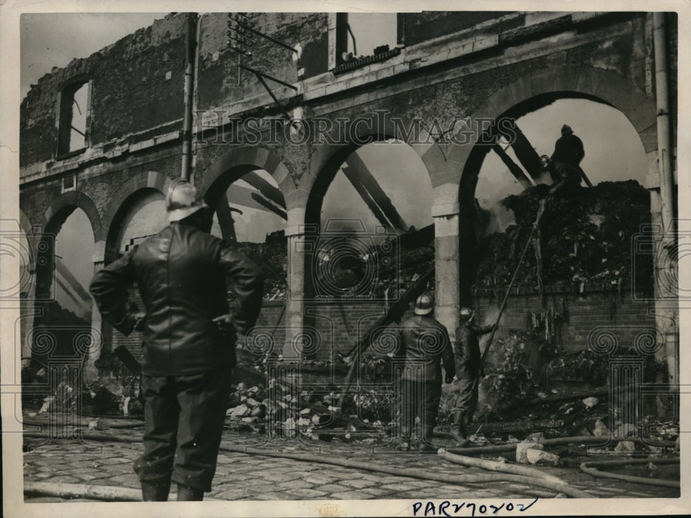 1934 Press Photo Paris Firemen at the wall of Smouldering Ruins in - Historic Images