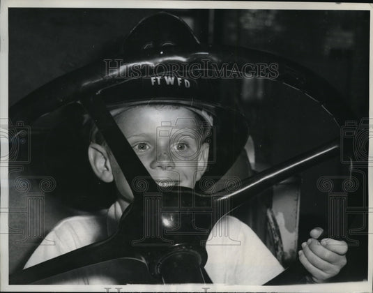 1961 Press Photo Darrel Coxsey in huge wheel of a big Fire Truck in Texas. - Historic Images