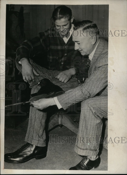 1931 Press Photo Harry Meoszy & his size 18 shows at a cobblers in Milwaukee WI-Historic Images