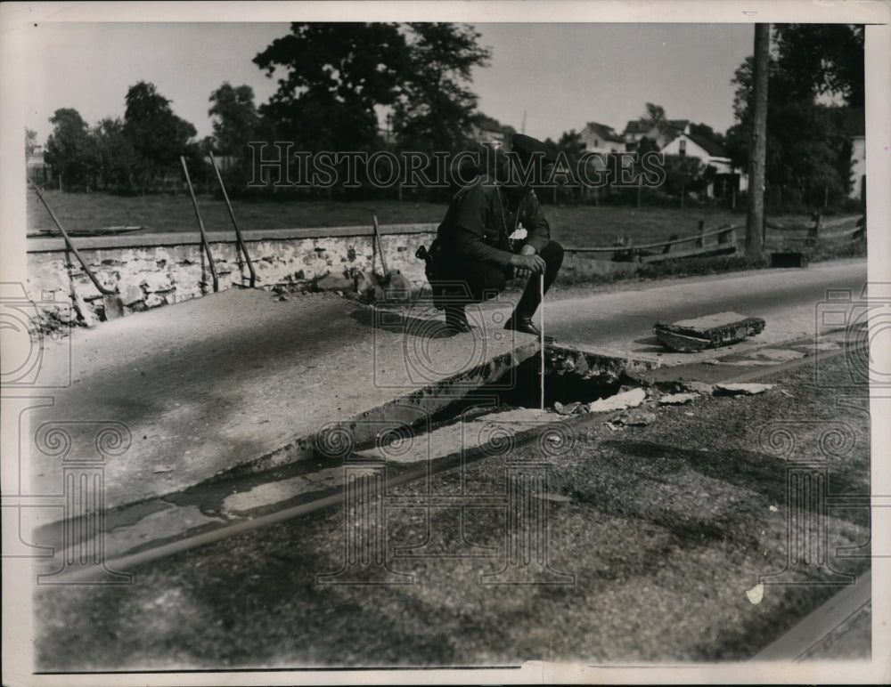 1937 Press Photo Officer John Ferry Looks At Section of Road Buckled Due to Heat-Historic Images