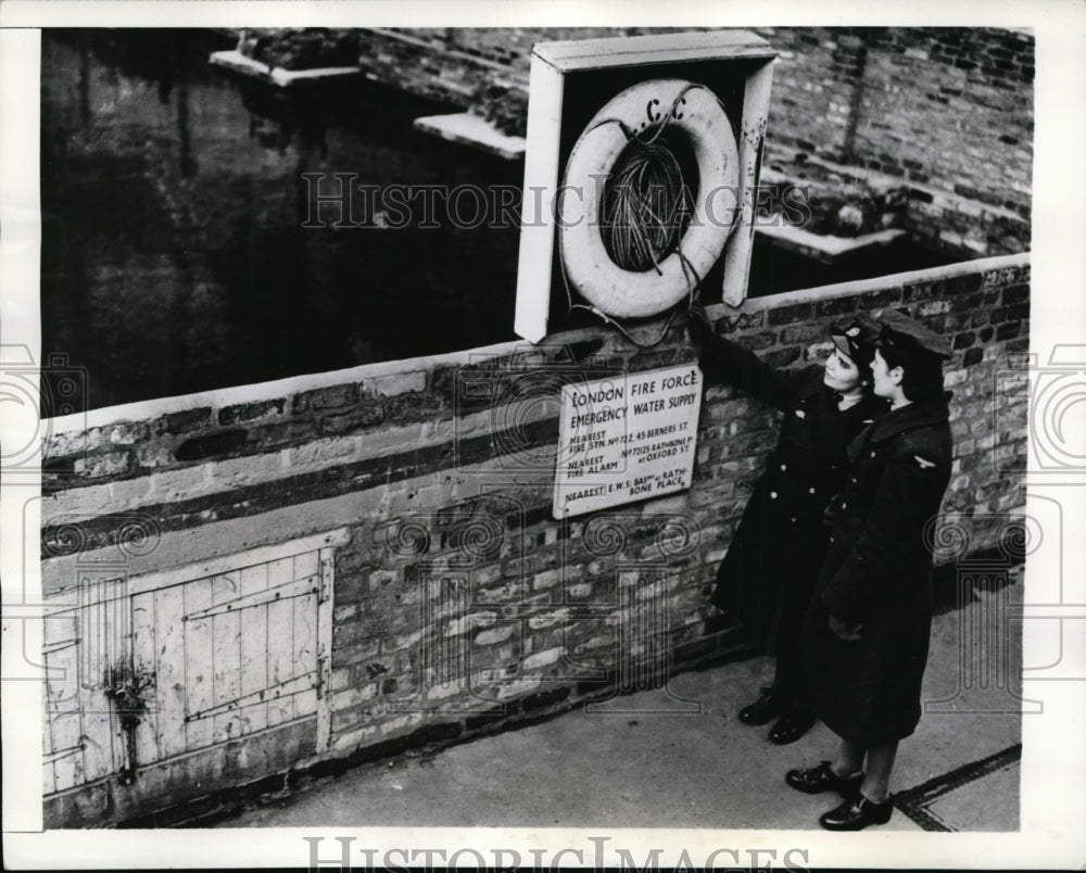 1942 London WAAF members inspect lifebelts placed beside pool - Historic Images