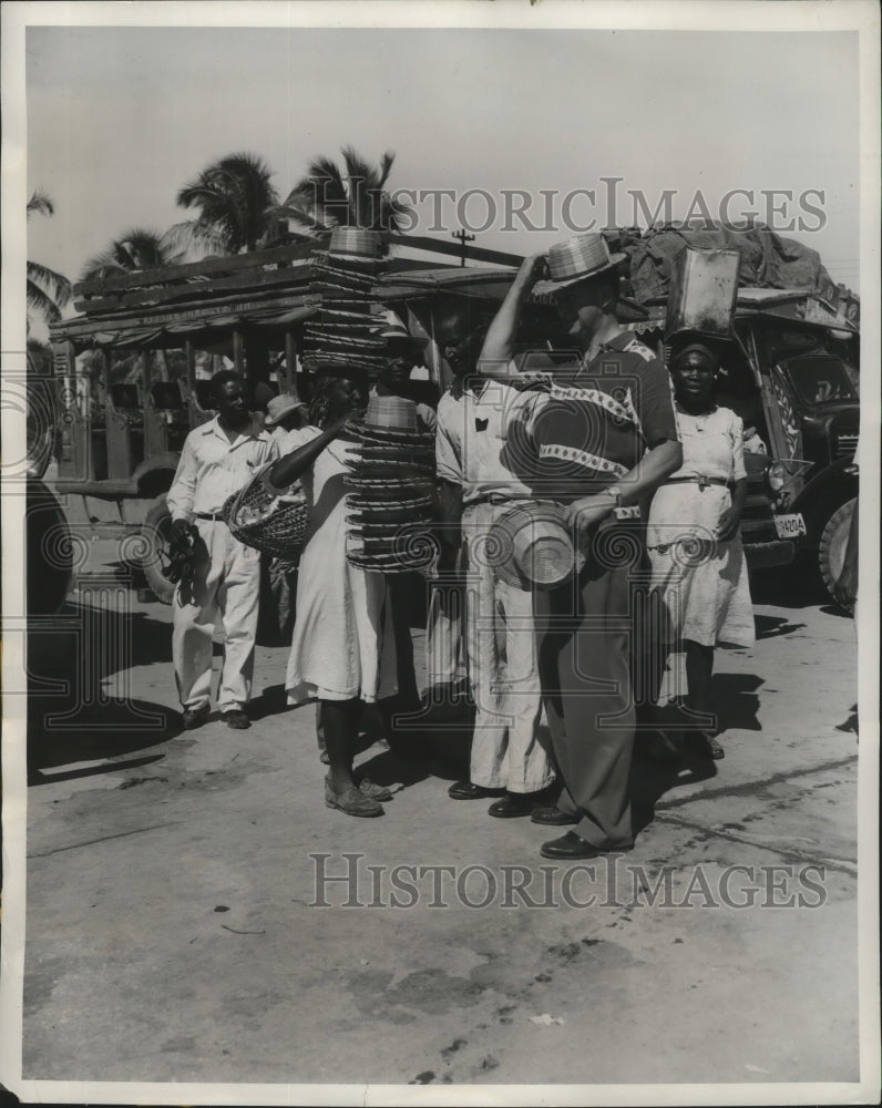 1951 Press Photo Hat salesgirl and tourist meet in Port-au-Prince, Haiti-Historic Images