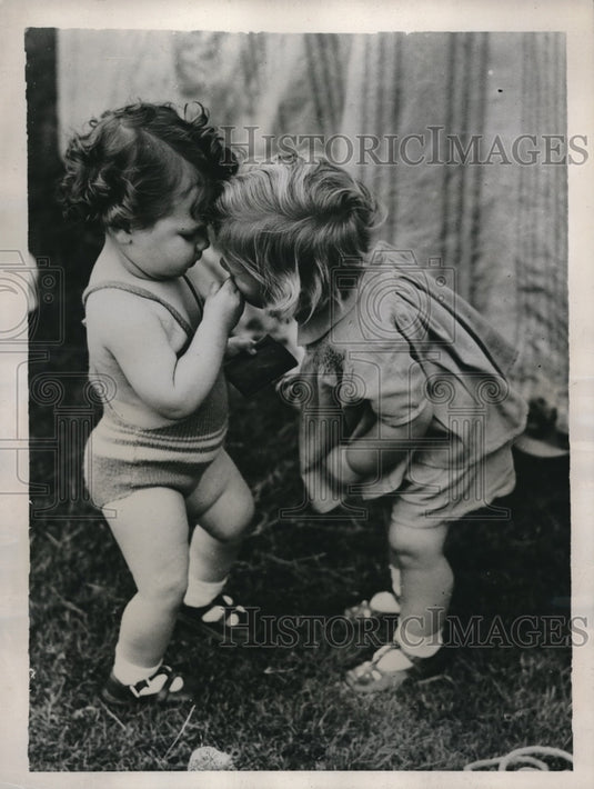1938 Press Photo One Toddler Kisses The Hurt Spot of Another Toddler in England - Historic Images