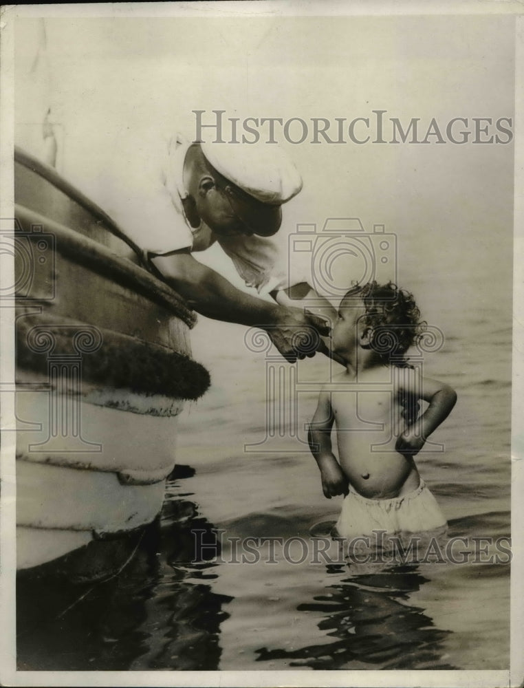 1932 Press Photo Youngster Peers at Boatmen on Sheerness in England - Historic Images