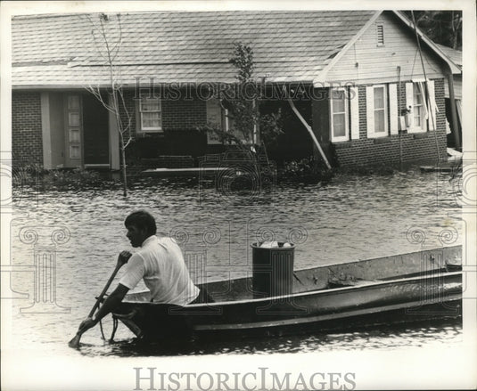 1969 Hurricane Camille - Man paddles boat in Citrus City. - Historic Images