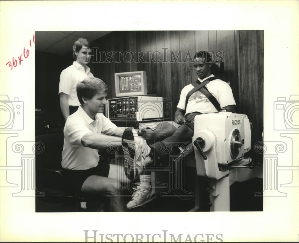 1990 Saints Trainers Work Kim Phillips on Biodex Machine - Historic Images