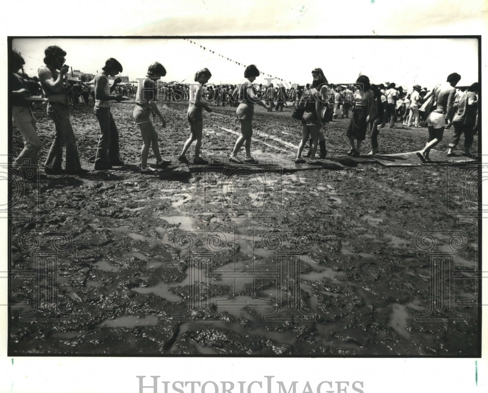 1980 Press Photo New Orleans Jazz Festival - Attendees walk across muddy area. - Historic Images