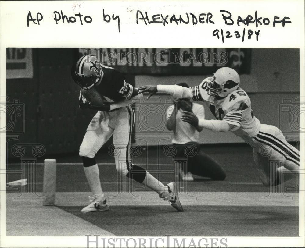 1984 Press Photo New Orleans Saints Player Avoiding Diving Cardinals Player - Historic Images