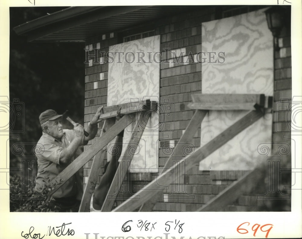 1988 Hurricane Gilbert - Clyde Kennair boards up home in preparation - Historic Images