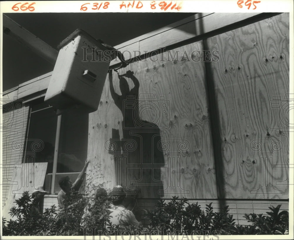 1988 Hurricane Gilbert - David Driscoll boards up Kenner City Hall. - Historic Images