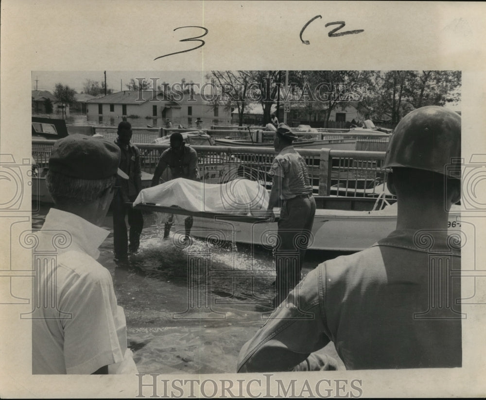 1965 Hurricane Betsy- Rescue workers recover body. - Historic Images