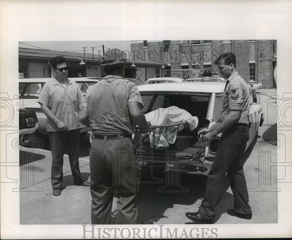 1965 Hurricane Betsy Workers load a recovered body. - Historic Images