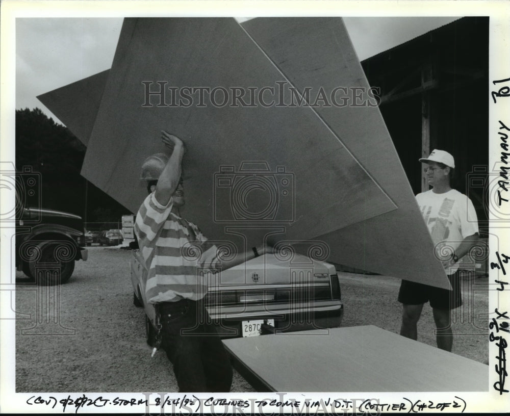 1992 Hurricane Andrew - James Wilson and Vincent Sara load plywood. - Historic Images