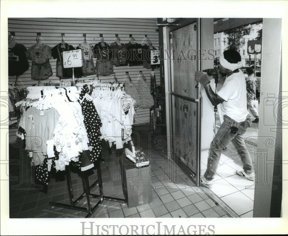 1992 Hurricane Andrew - Woman boards up store windows and doors. - Historic Images