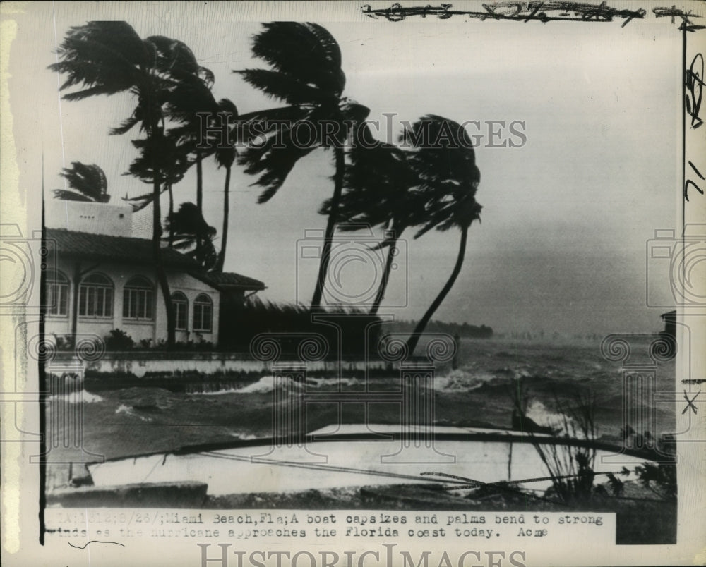 1949 Hurricane- A boat capsizes and palms bend to winds. - Historic Images