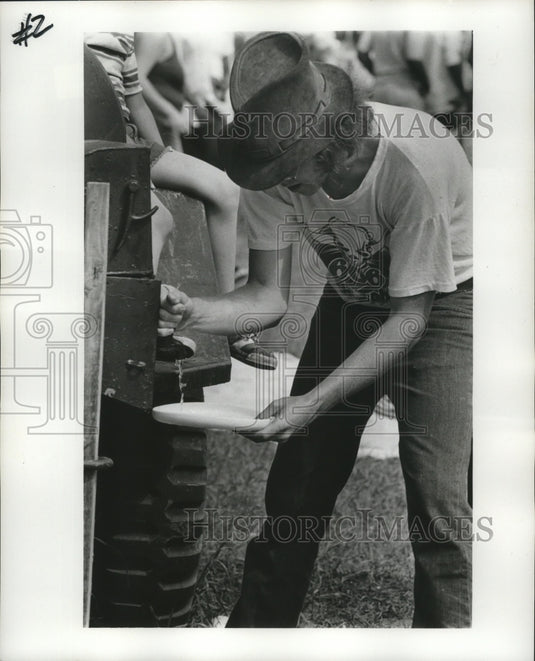 1977 Press Photo Getting a drink at New Orleans Jazz and Heritage Festival. - Historic Images