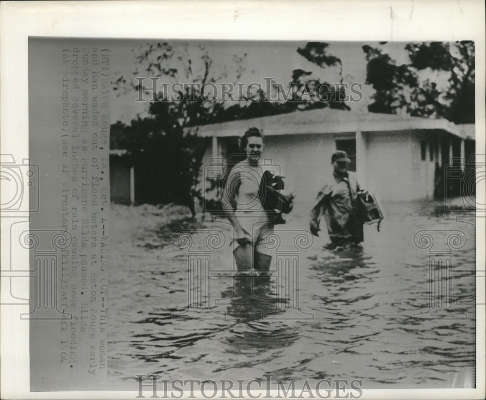 1964 Hurricane Hilda- Woman and man wading out of flood waters. - Historic Images