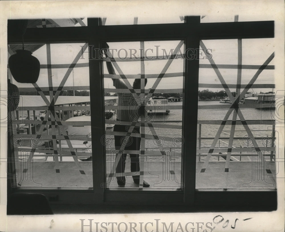 1964 Hurricane Hilda- Masking tape goes on lakefront marina windows. - Historic Images