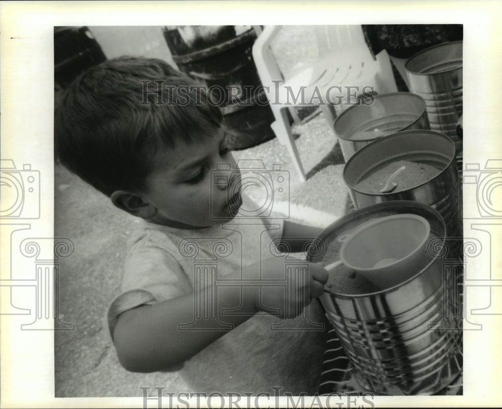 School Fair- Tyler Guidry, 3, looks at choices of colored sand.-Historic Images