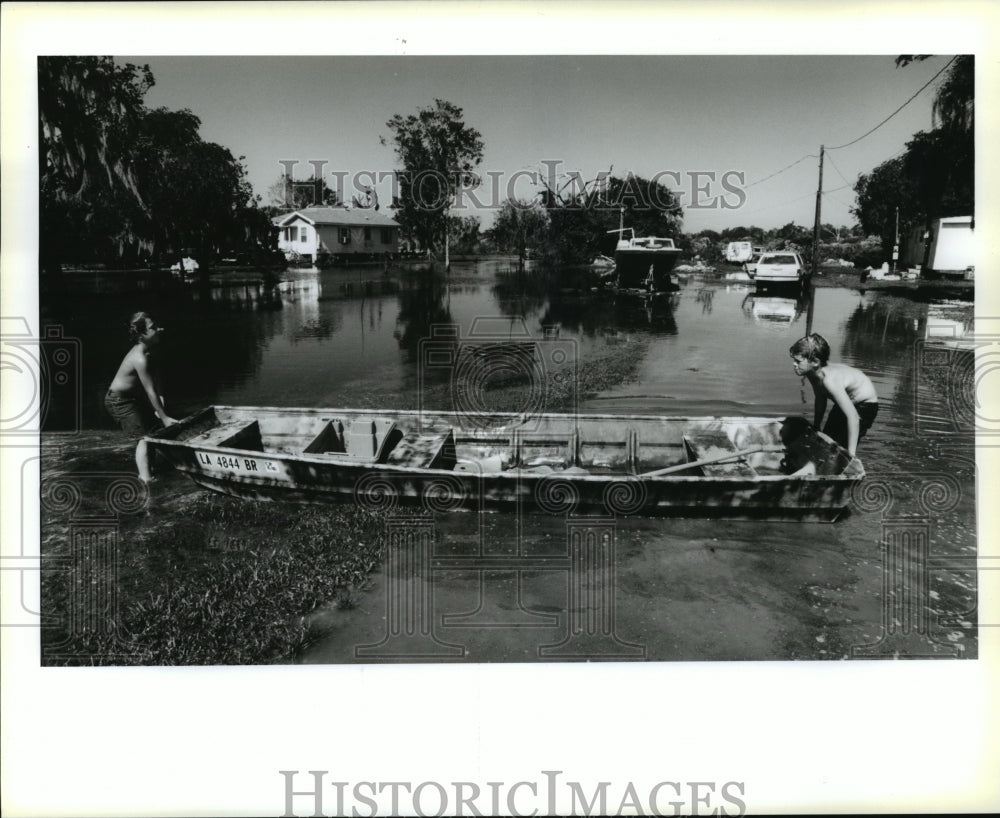 1995 Hurricane Opal-Boys play with flatboat in flooded yard. - Historic Images