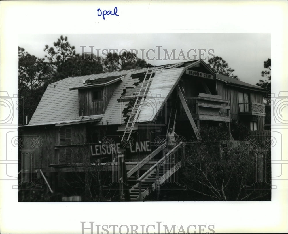 1995 Hurricane Opal- Eric bloom repairs his storm damaged roof. - Historic Images