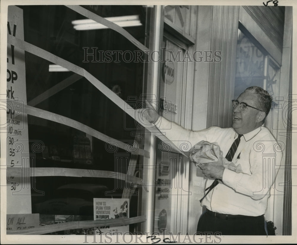 1964 Hurricane Hilda- Edwin A. Rosser removes tape from window. - Historic Images