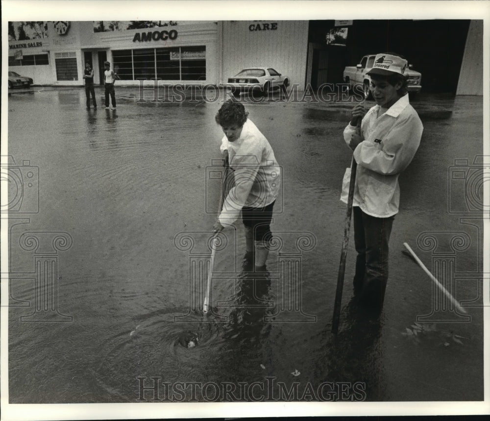 1985 Hurricane Elena-Judy Brown and her son Will unplug street drain - Historic Images