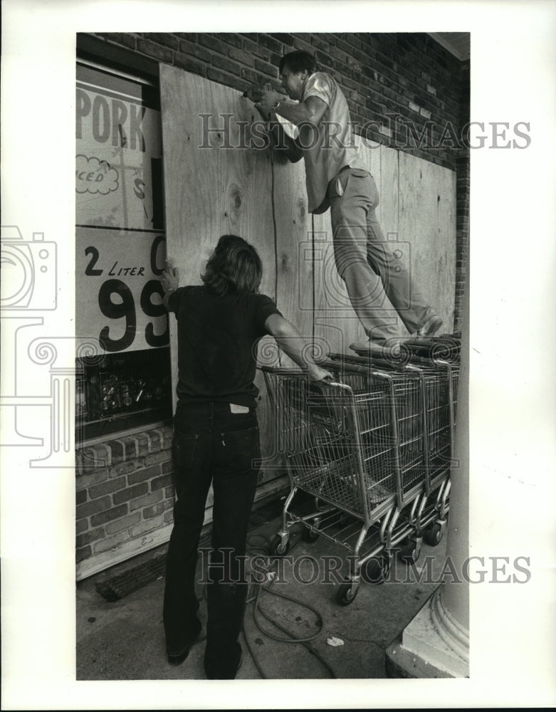 1985 Hurricane Elena Ernest Koch bording up IGA Grocery store - Historic Images