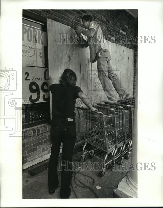 1985 Hurricane Elena Ernest Koch bording up IGA Grocery store - Historic Images