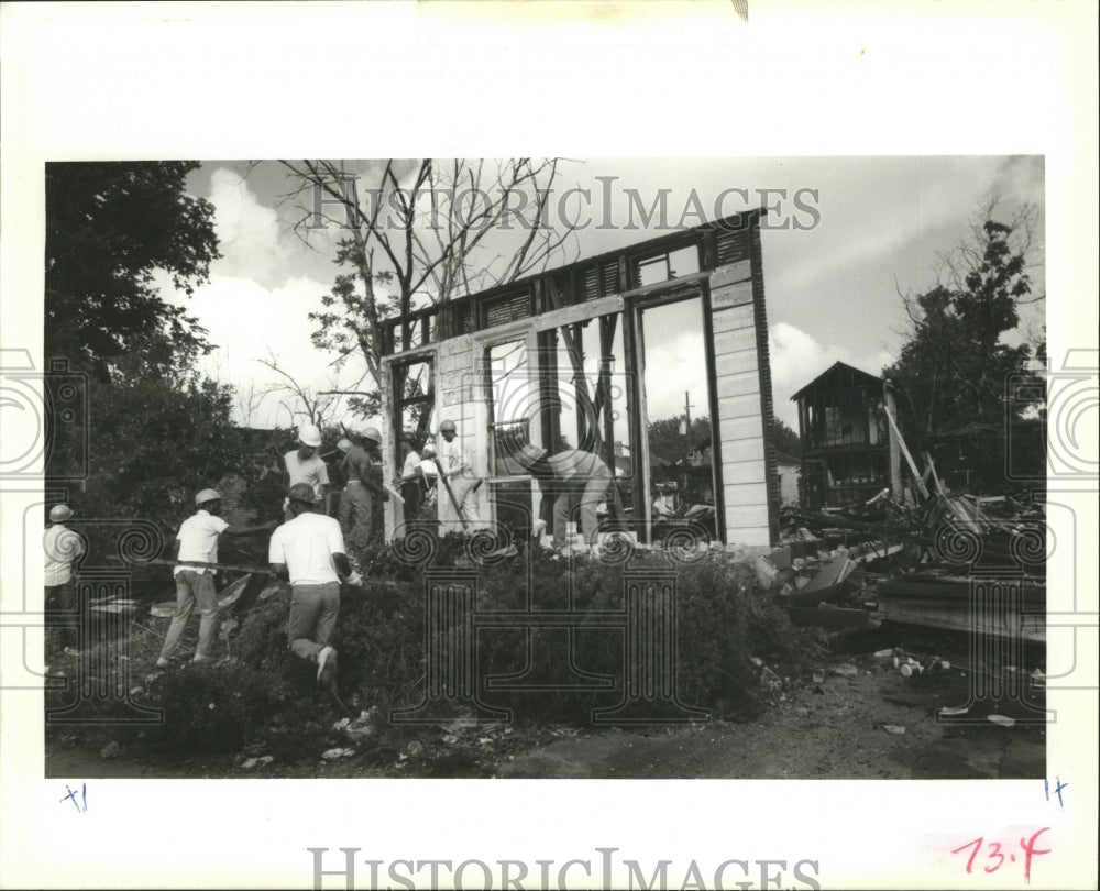 1989 Orleans Parish Prison inmates clear away burned out buildings. - Historic Images