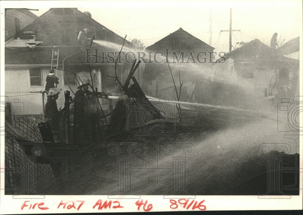 1985 Firefighters hose down remains of abandoned house. - Historic Images