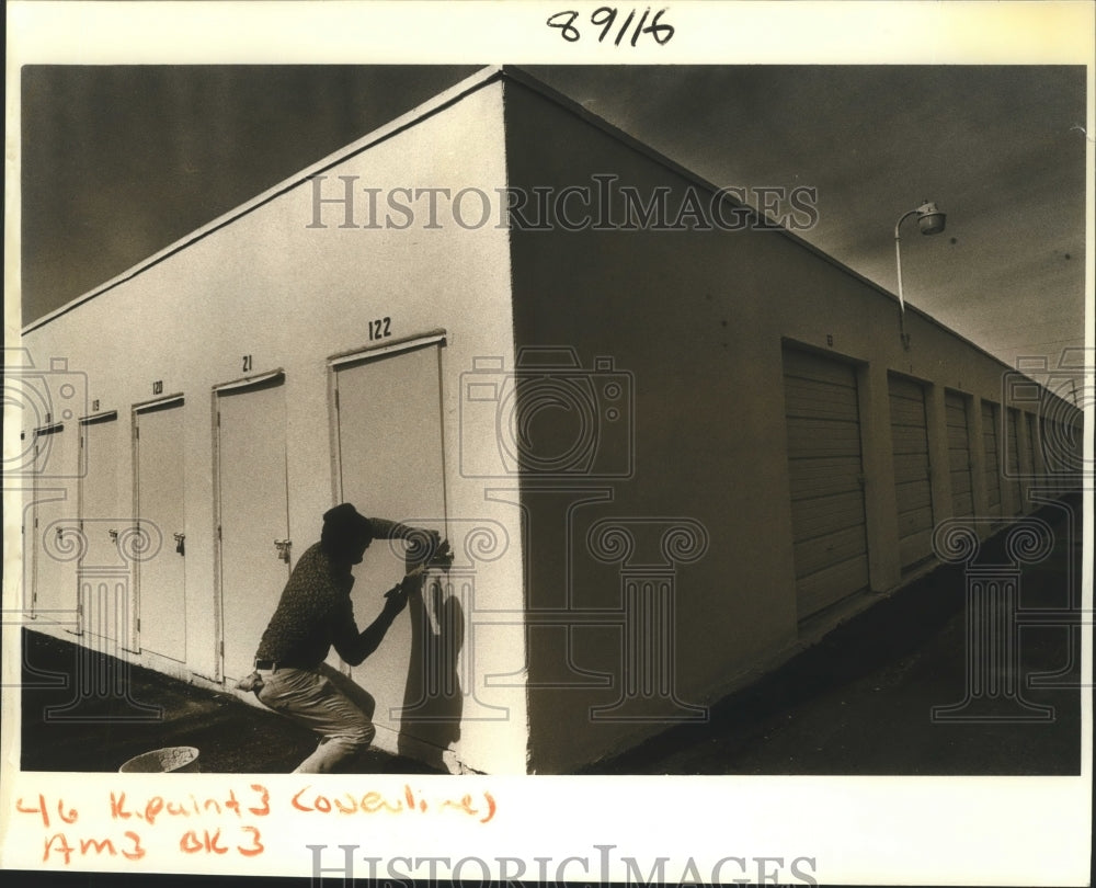 1988 Dennis Michael paints a door on a AAA storage unit in Hickory - Historic Images