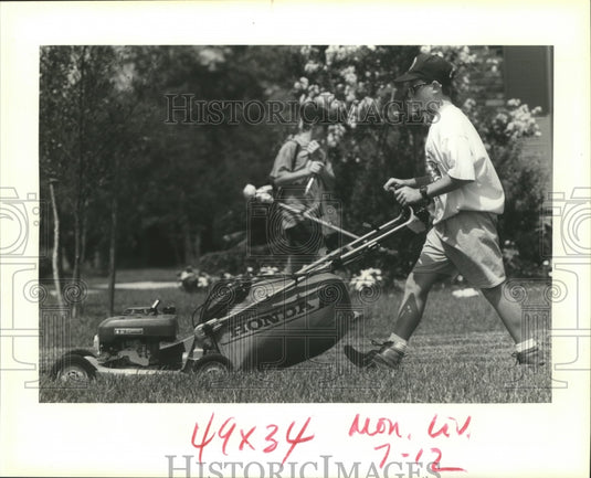 1993 Keith West, 14, & brother Neil, 12 work on a lawn in Metairie - Historic Images