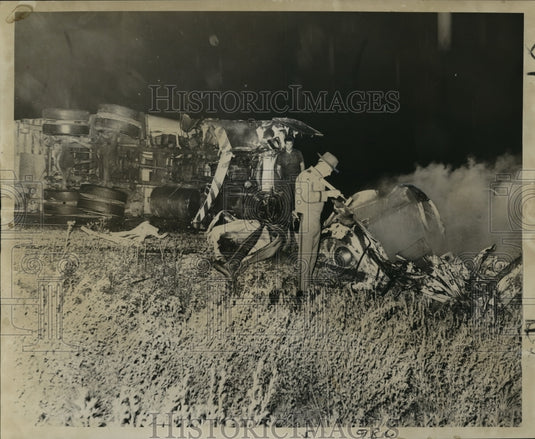1966 Accidents- Trooper checks charred wreckage of small car. - Historic Images