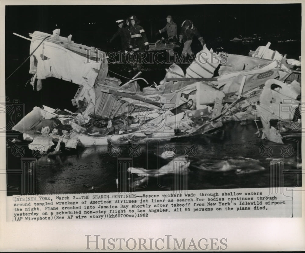 1962 Airplane Accidents- Rescue workers wade through shallow waters. - Historic Images