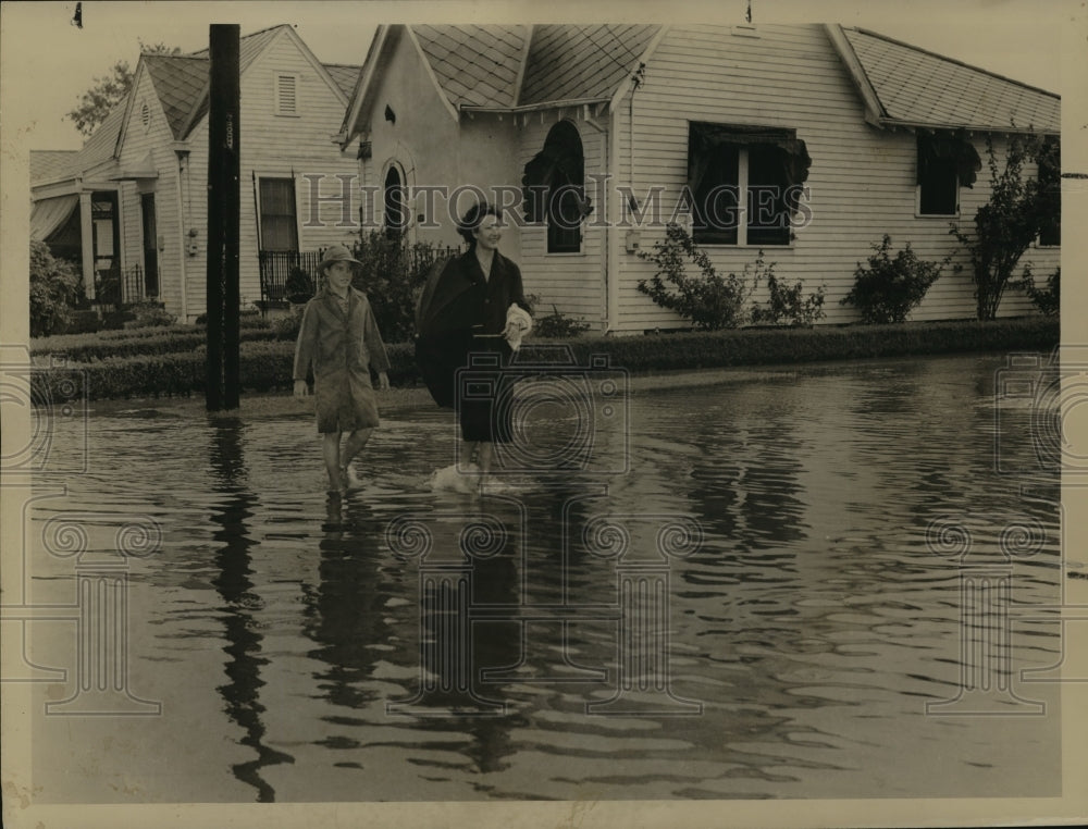 1948 Mary and Charles Cruz walk through flood waters on Alvar St. - Historic Images