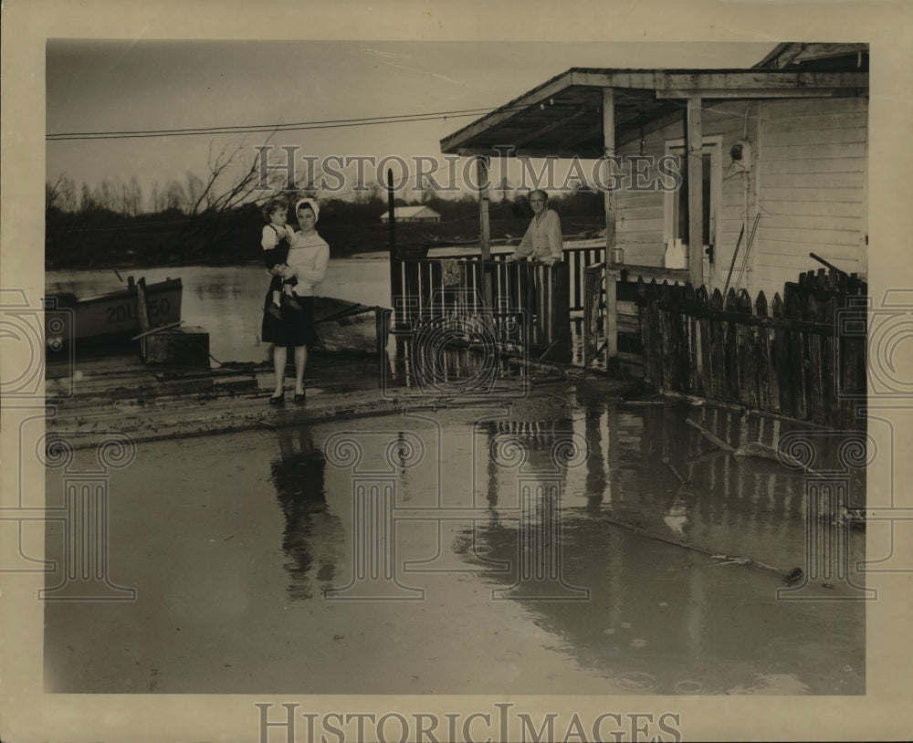 1948 Andrew Anderson and family view flooding around his home. - Historic Images