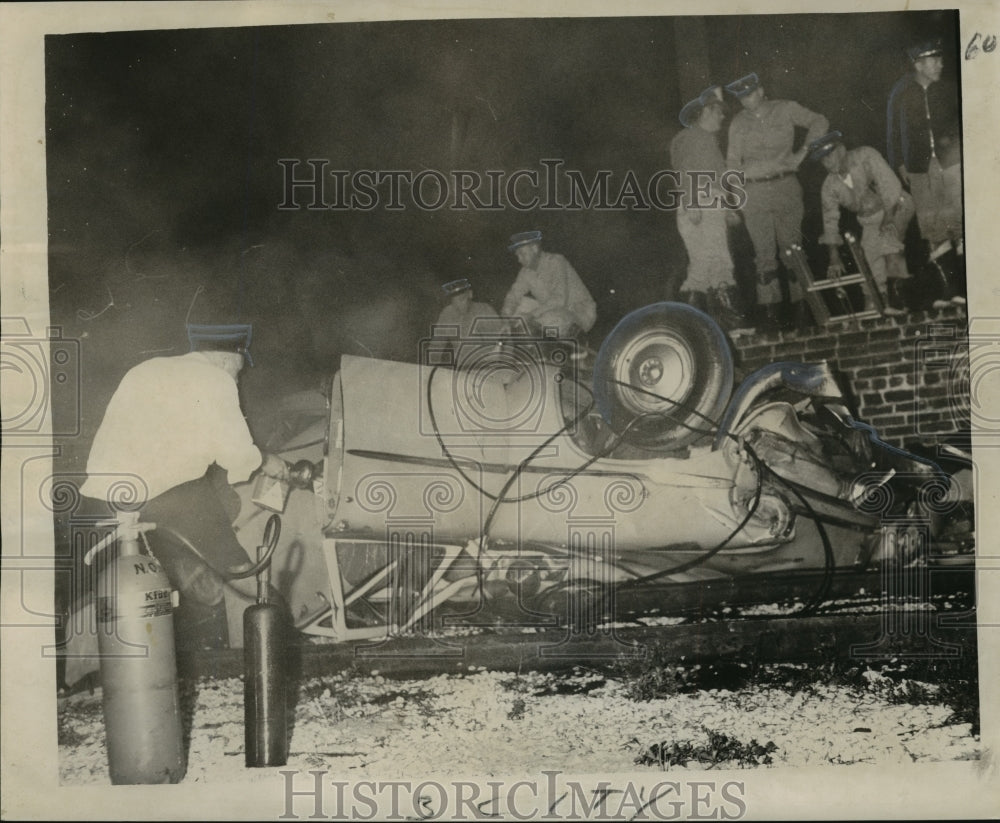 1965 Accidents-Firemen peers with flashlight into auto that crashed - Historic Images