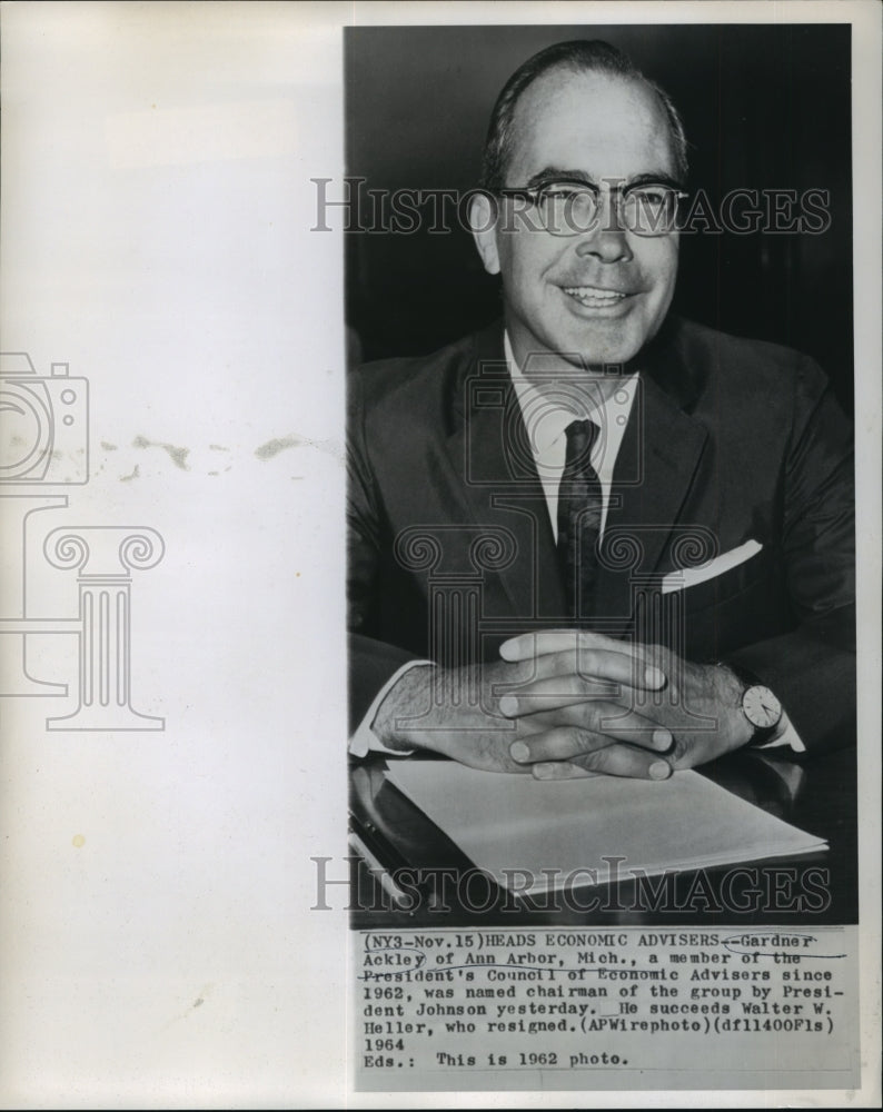 1962 Gardner Ackley smiles at desk - Historic Images