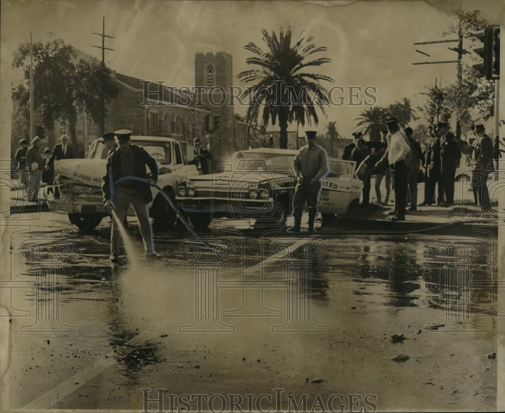 1967 Accidents - Firemen hose down Claiborne Street after wreck. - Historic Images