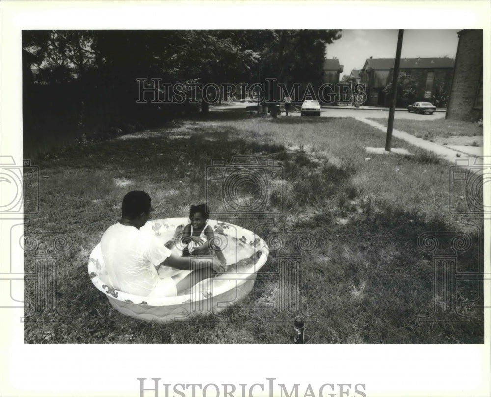 1994 Lawrence Harris and his daughter cool off near their apartment - Historic Images