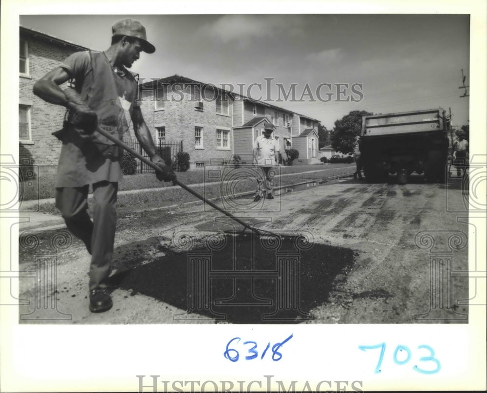 1989 Adrian Cambridge fills a hole with the Adopt a Pothole program - Historic Images