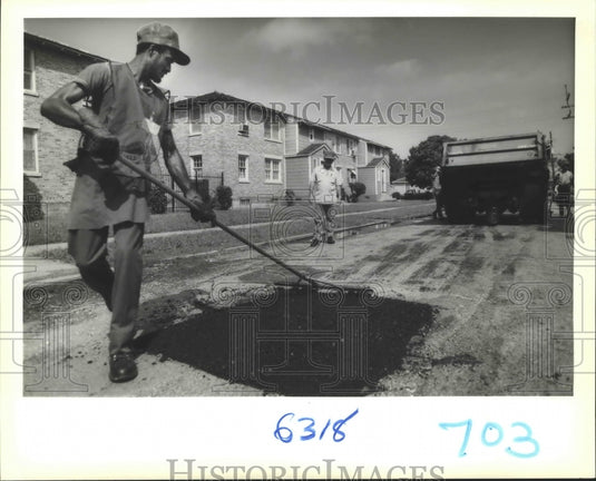 1989 Adrian Cambridge fills a hole with the Adopt a Pothole program - Historic Images