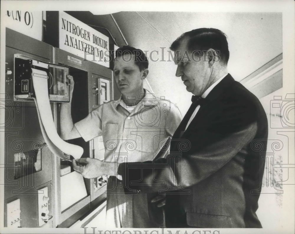 1967 Air pollution officials study recording tape in St. Louis. - Historic Images