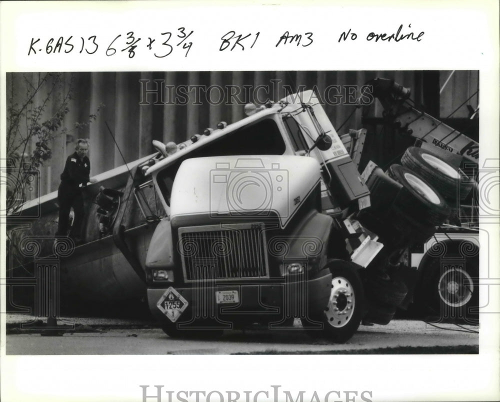 1991 Accidents- Tow truck operators prepare to right a tanker truck. - Historic Images