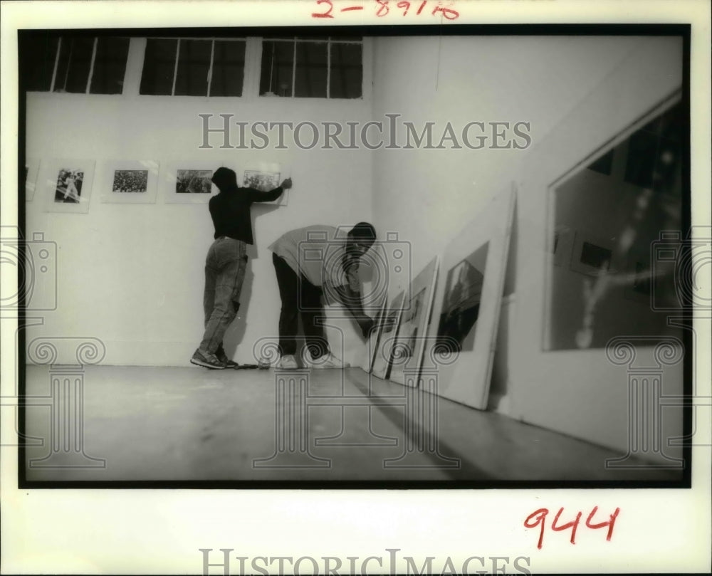 1989 Chandra McCormick and Keith Calhoun place their photos on wall. - Historic Images