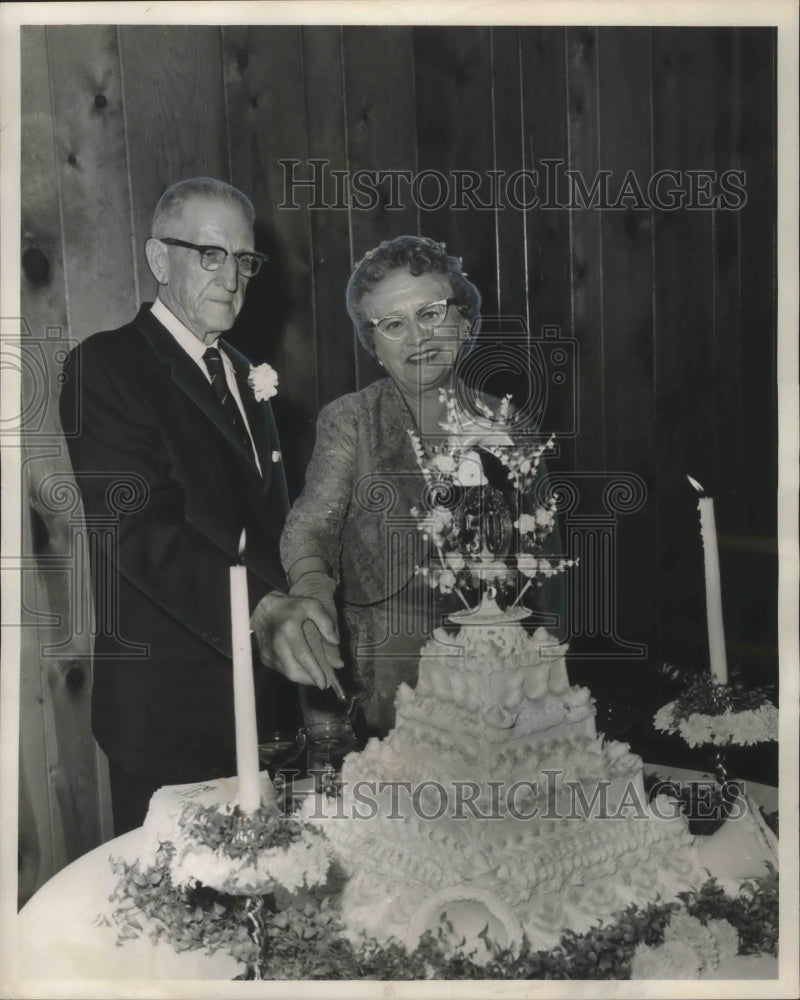 1961 Mr. and Mrs. John Henry Adams cut their golden cake. - Historic Images