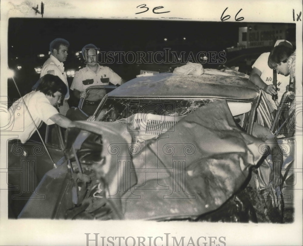 1975 Press Photo Police work to remove man trapped inside his auto after crash - Historic Images